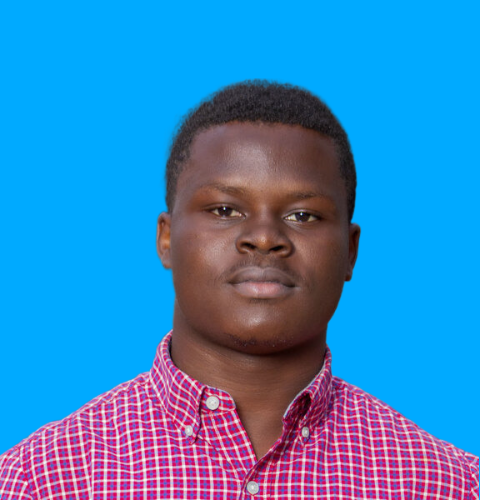 young boy (Yvon MENSAH) standing in front of blue background